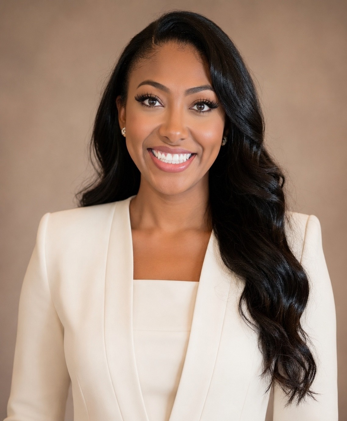 Ellesia Thurmond in an ivory suit, smiling in a polished portrait.