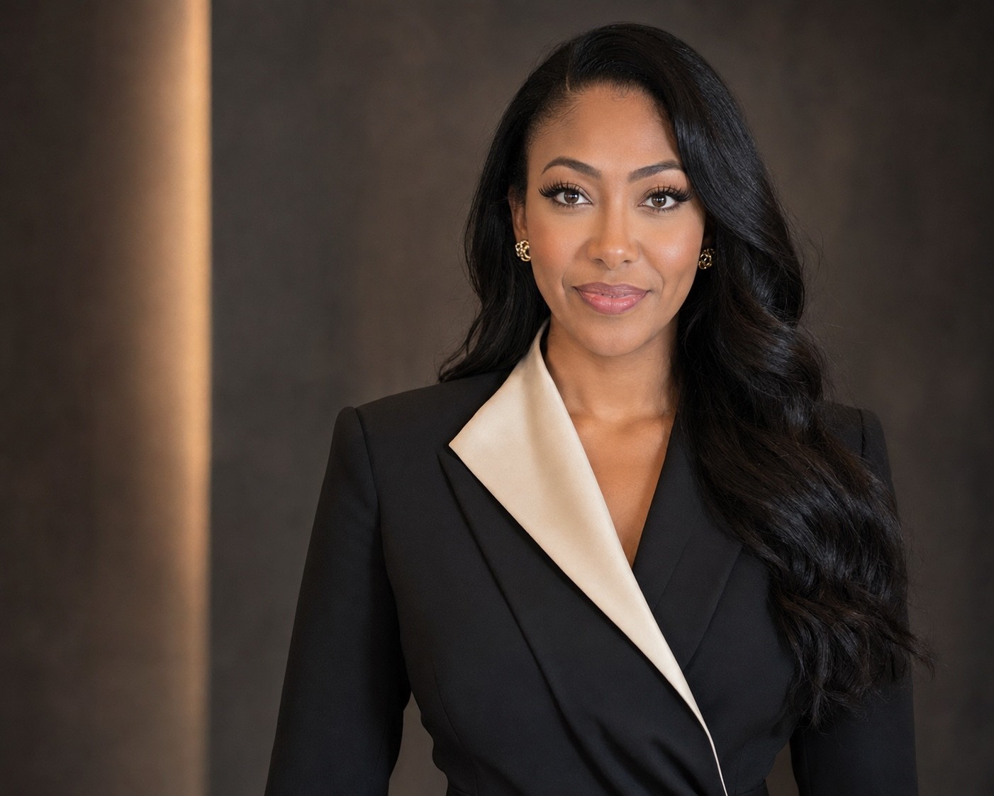 Ellesia Thurmond in a black suit with an ivory lapel in a warm editorial portrait.